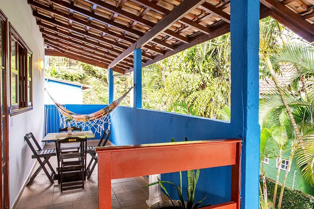 Apartment balcony with a hammock, a table and the garden