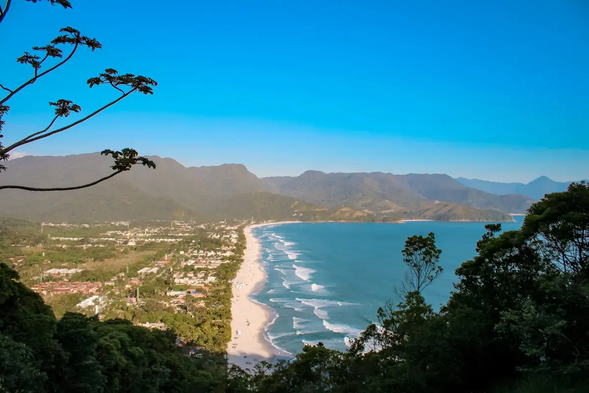 View from above of Maresias beach, the strip of sand between the blue sea and the green hills