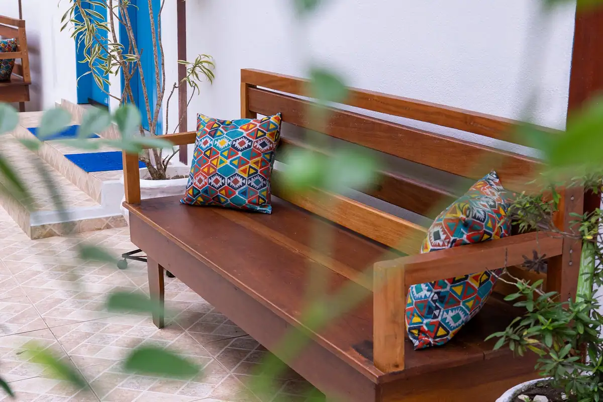 The inn's porch with a wooden bench and colorful cushions