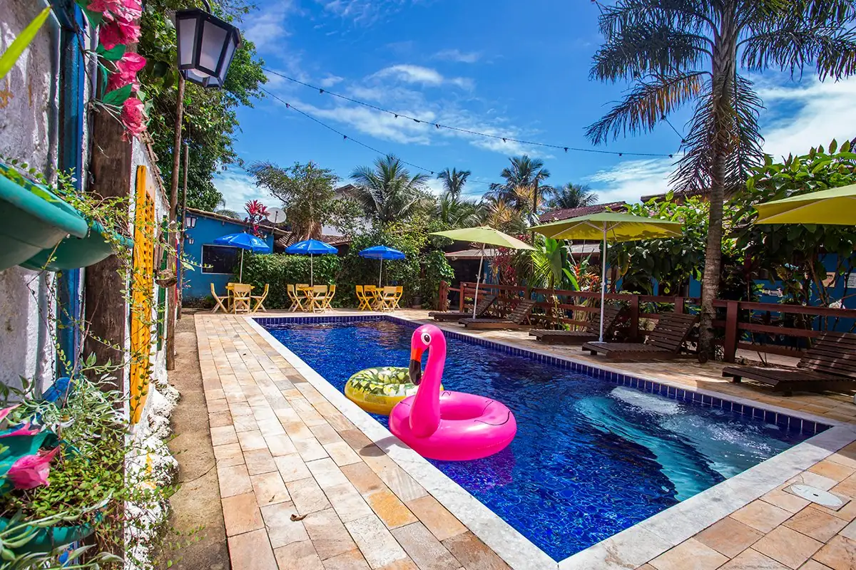 Piscina aquecida com boia de flamingo e palmeiras