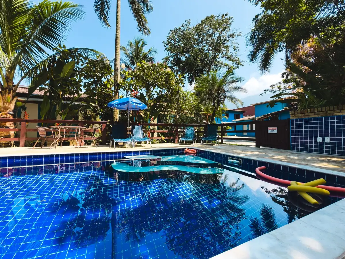 Pool with palm trees and blue umbrellas on a sunny day