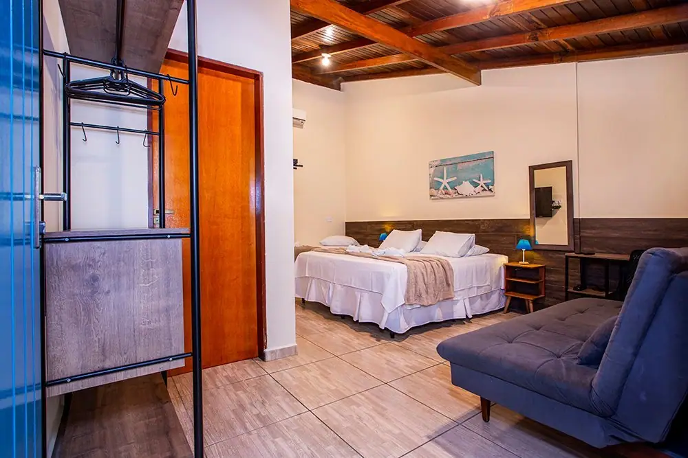 Deluxe Suite at Pousada Villa Blu in Maresias, with a king bed and a blue sofa