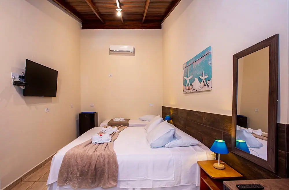 King bed in the Deluxe Suite with a mirror and smart TV