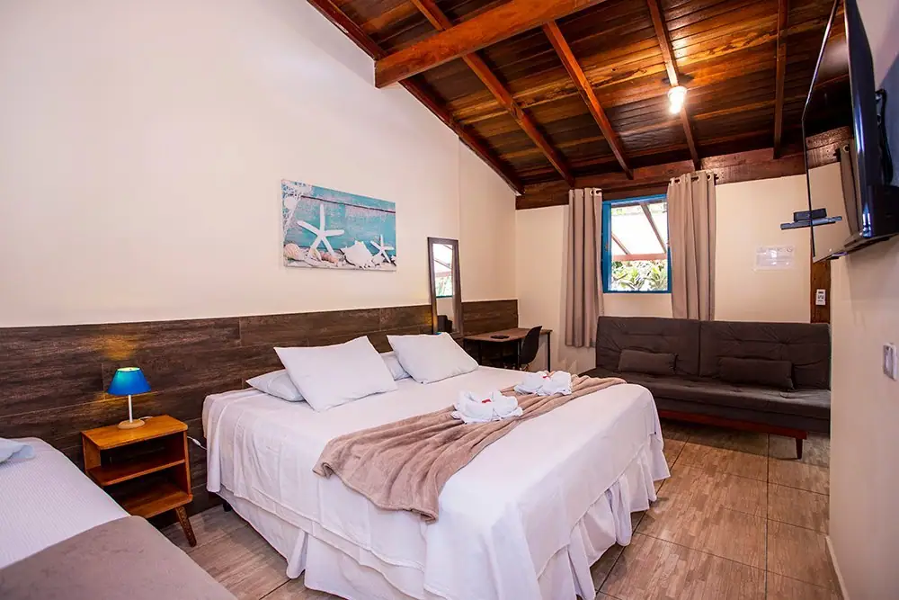 Deluxe Suite with a king bed, sofa and wooden ceiling
