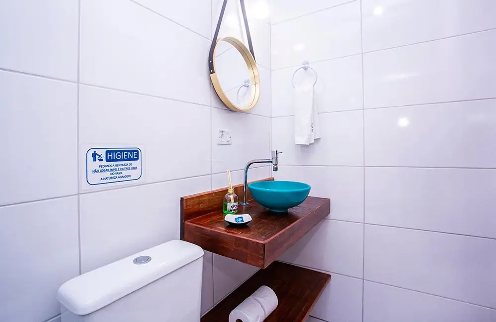 Blue basin sink and round mirror in the Economy Suite bathroom