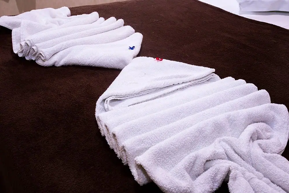 Folded towels on the bed in the Economy Suite
