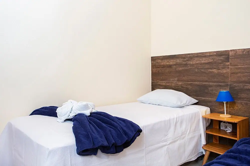 Single bed in the Standard Suite with a blue lamp